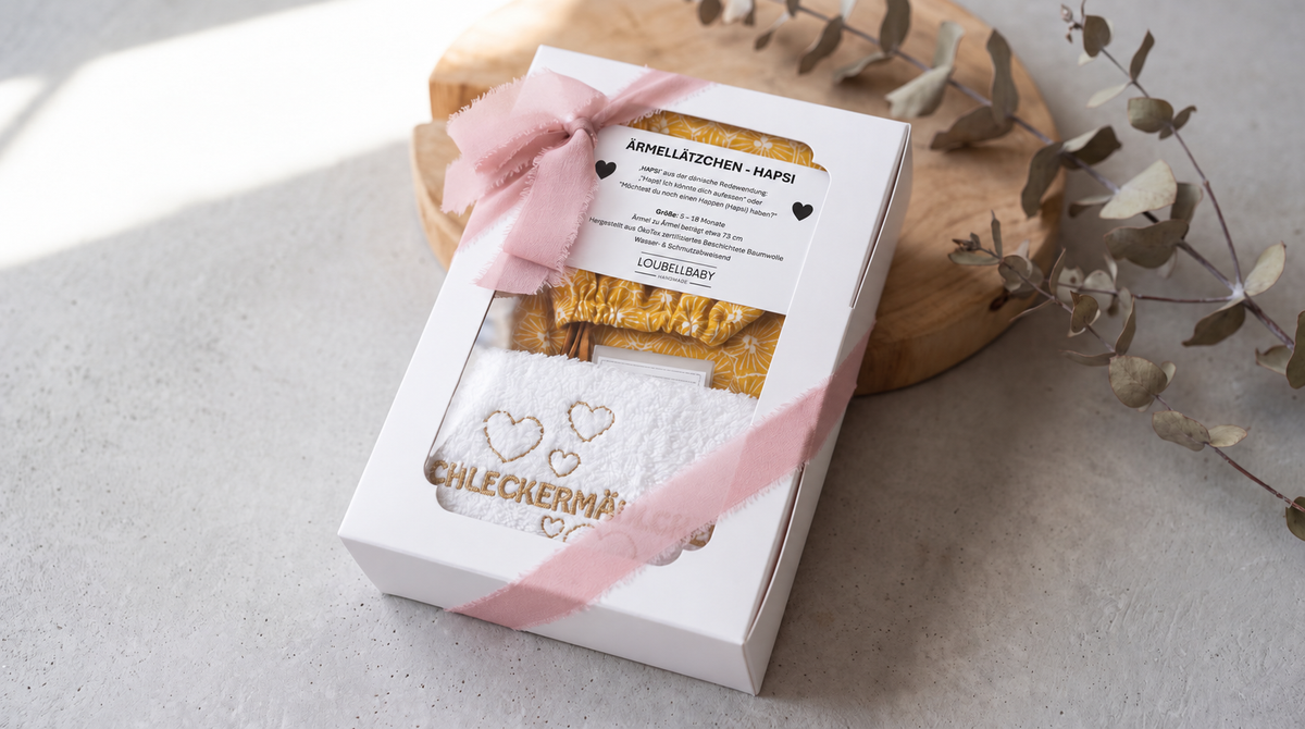 Geschenkbox Gelb mit rosa Schleife und besticktem Waschtuch
