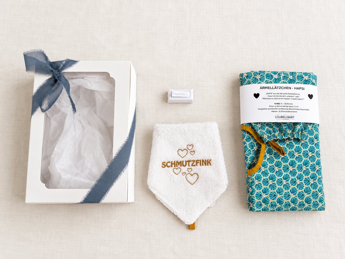 Geschenkbox, Waschtuch SCHMUTZFINK und türkises HAPSI nebeneinander