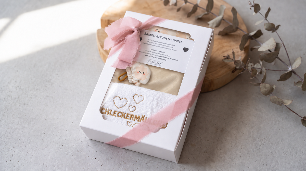 Geschenkbox Klecksi Beige mit rosa Schleife und besticktem Waschtuch