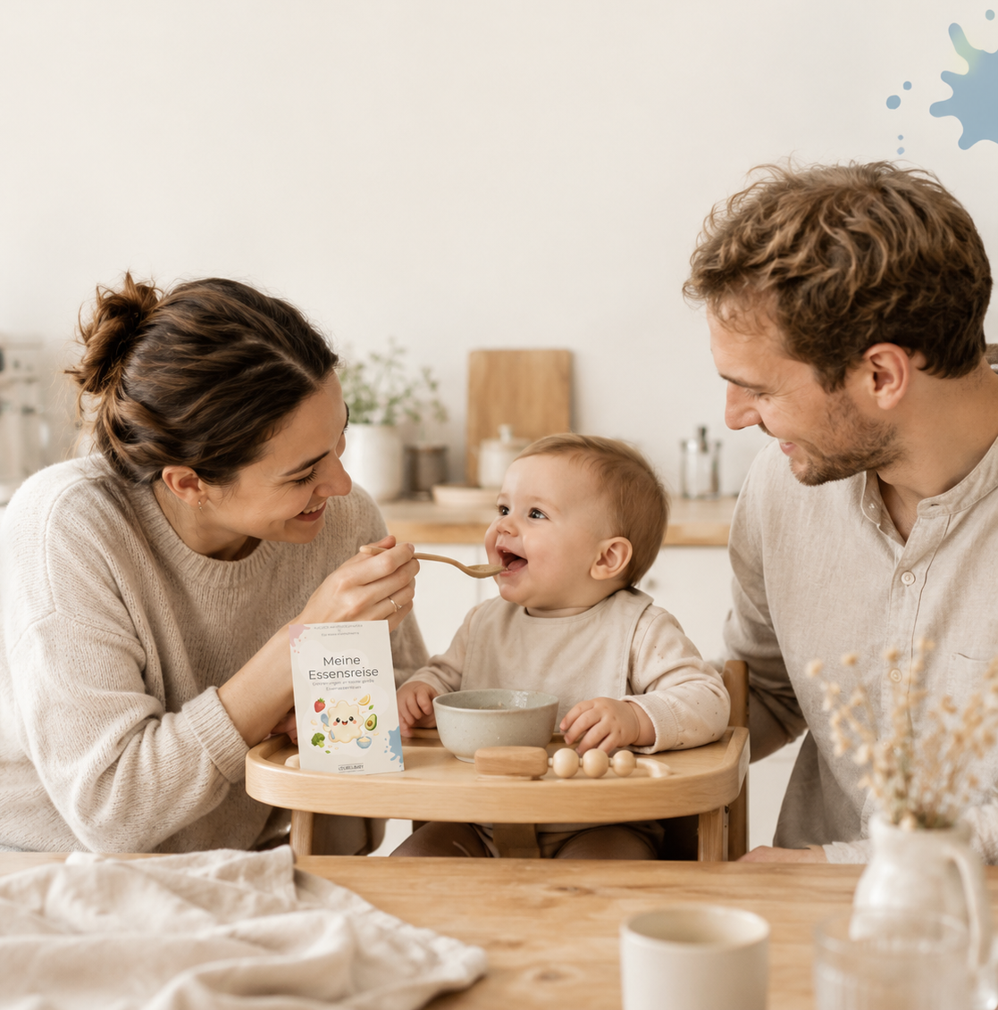 Eltern mit Baby beim Essen, im Vordergrund eine Meilensteinkarte