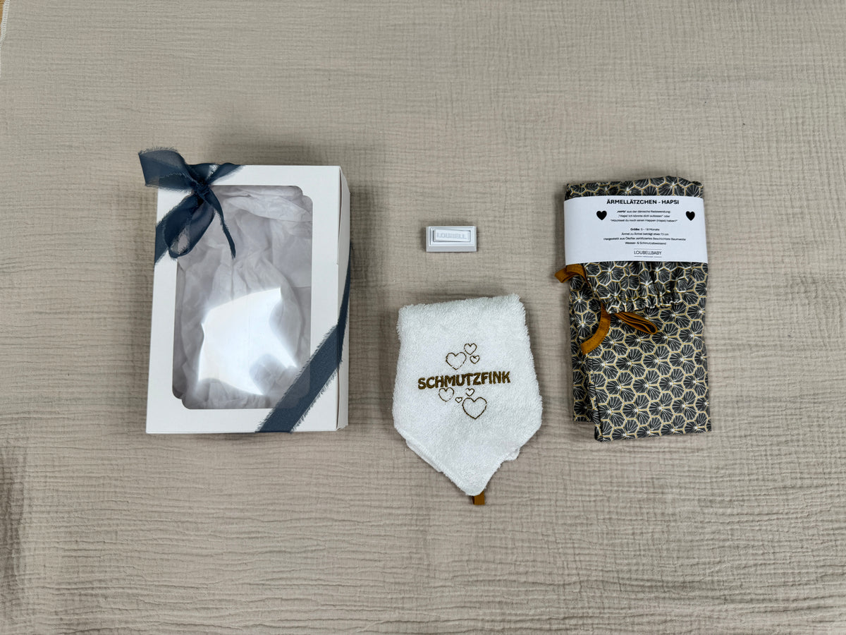 Geschenkbox, Waschtuch und graues HAPSI nebeneinander