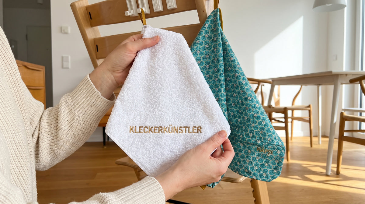 Waschtuch KLECKERKÜNSTLER wird am Hochstuhl hochgehalten