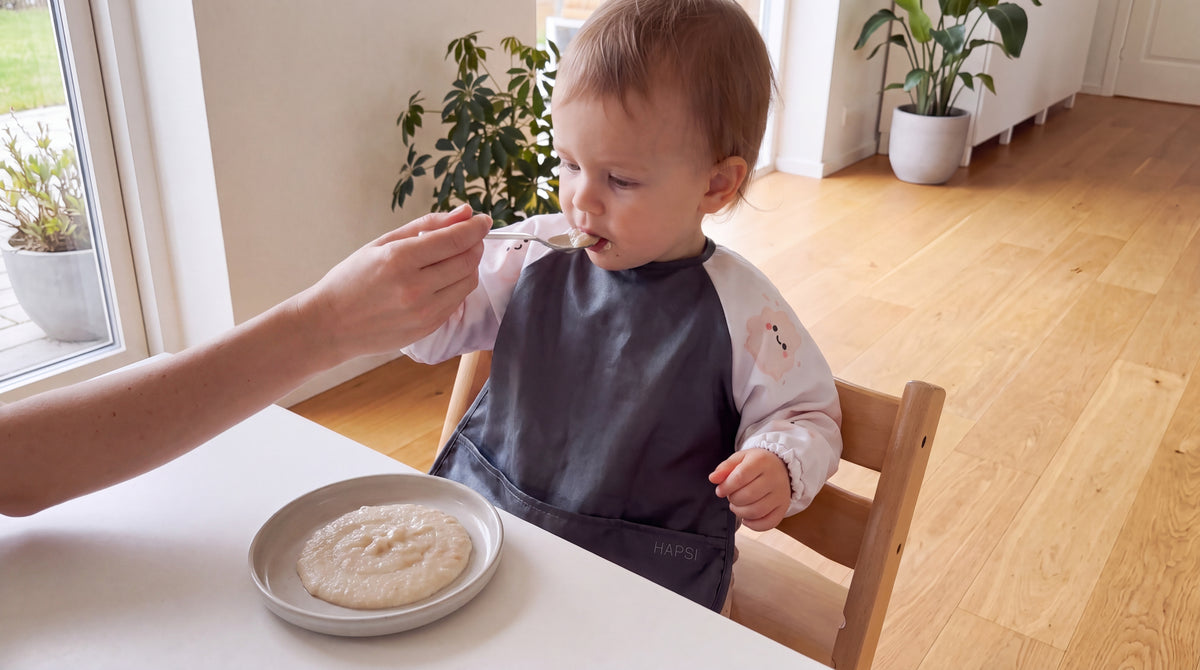 Baby mit HAPSI Anthrazit wird mit dem Löffel gefüttert