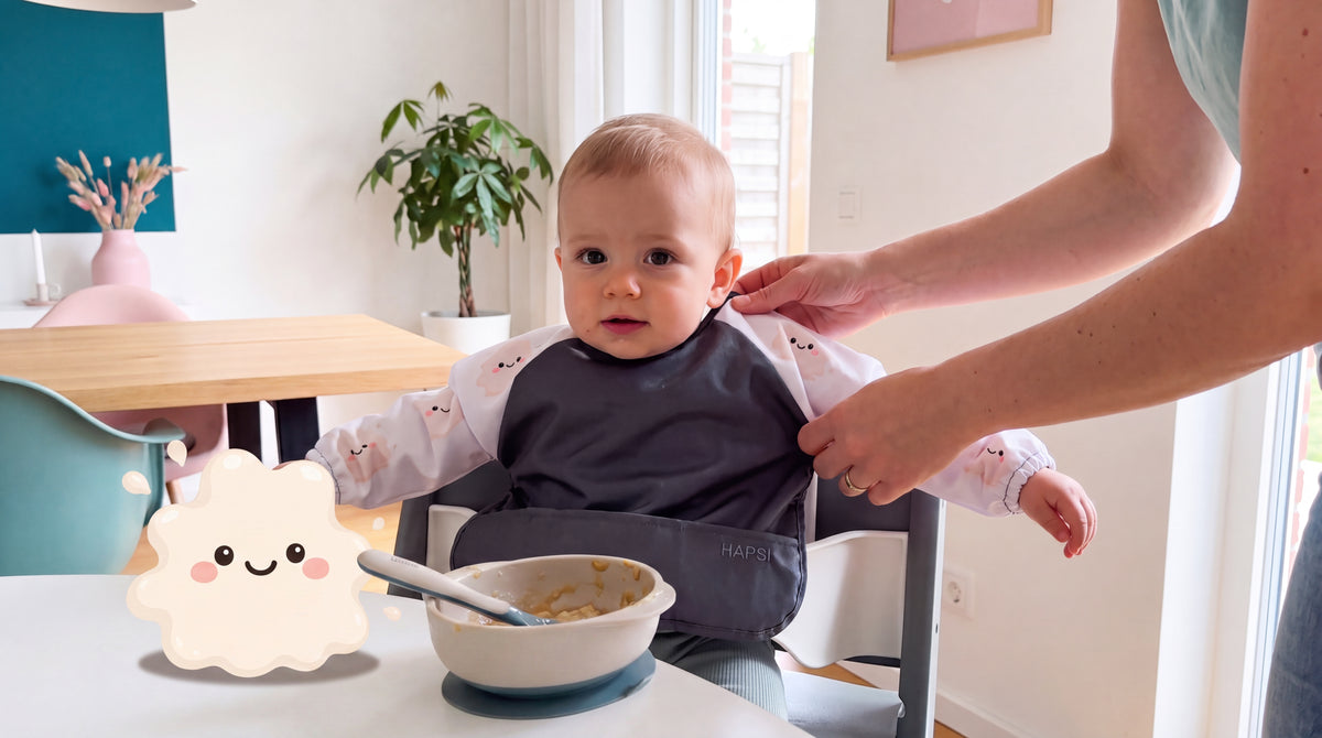 Baby mit HAPSI Anthrazit am Tisch, daneben Klecksi