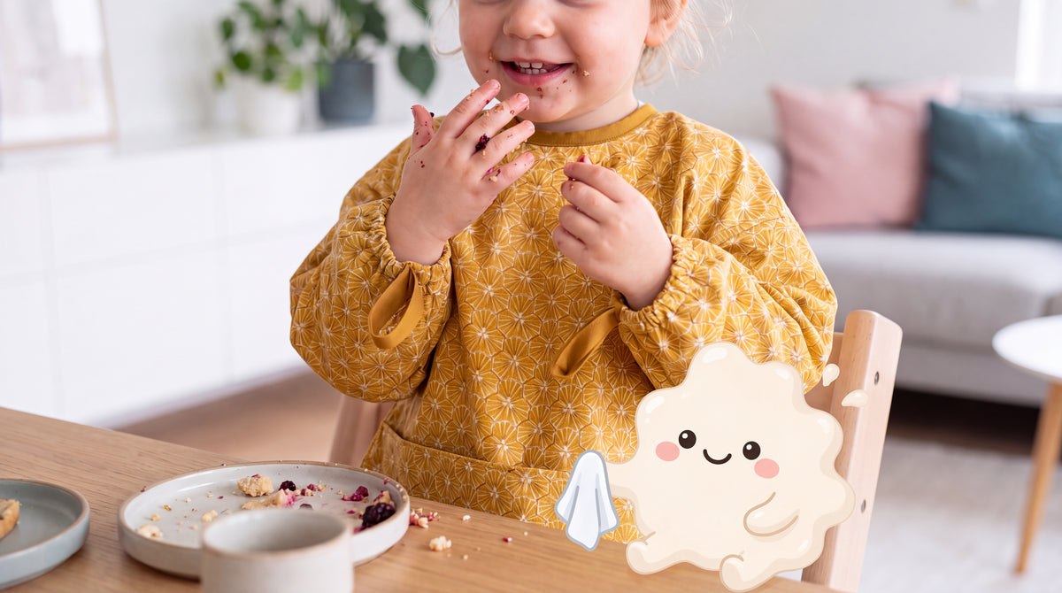 Lachendes Kind mit gelbem HAPSI Ärmellätzchen, daneben Klecksi