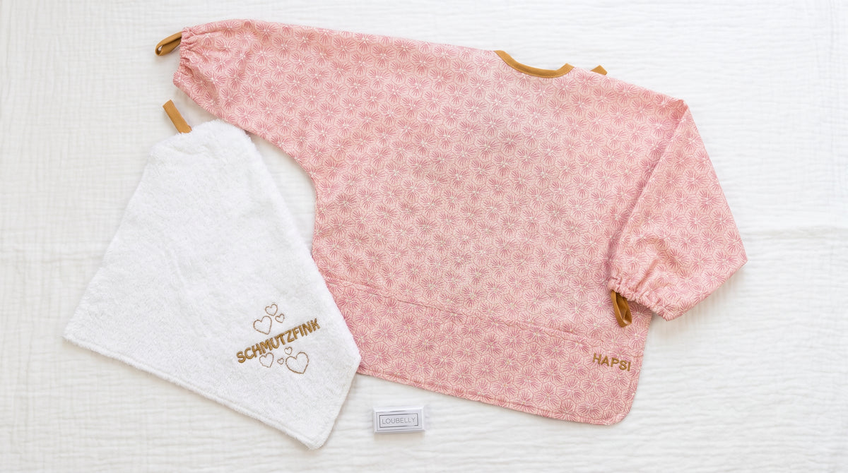 Kleine Essens-Entdecker-Box Rosa: rosa HAPSI Ärmellätzchen, besticktes Waschtuch SCHMUTZFINK und HAPSI Parkplatz