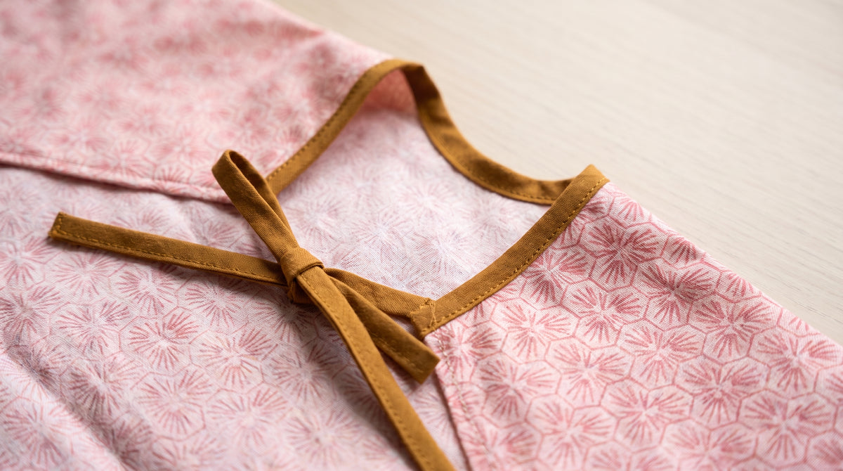 Detail der Rückenbindung am rosa HAPSI Ärmellätzchen